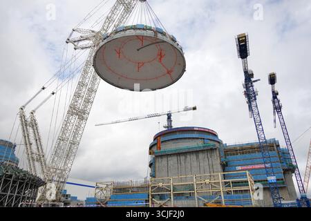 YANTAI, CHINE - 6 SEPTEMBRE 2025 - une grosse grue soulève la tête supérieure de la coque de sécurité de l'île nucléaire de l'unité 4 à la centrale nucléaire de Haiyang à Yantai, Shandong, Chine, le 6 septembre 2025. Banque D'Images