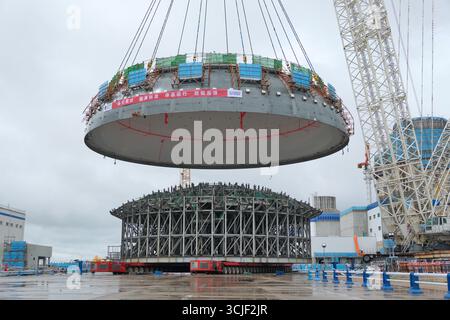 YANTAI, CHINE - 6 SEPTEMBRE 2025 - une grosse grue soulève la tête supérieure de la coque de sécurité de l'île nucléaire de l'unité 4 à la centrale nucléaire de Haiyang à Yantai, Shandong, Chine, le 6 septembre 2025. Banque D'Images