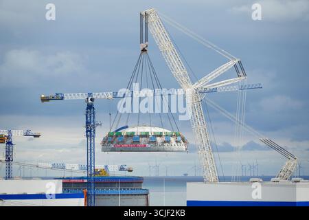 YANTAI, CHINE - 6 SEPTEMBRE 2025 - une grosse grue soulève la tête supérieure de la coque de sécurité de l'île nucléaire de l'unité 4 à la centrale nucléaire de Haiyang à Yantai, Shandong, Chine, le 6 septembre 2025. Banque D'Images