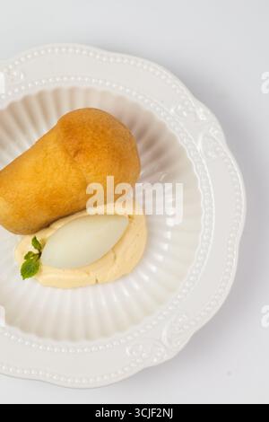 vue de dessus d'un dessert babka au rhum avec crème et sorbet en gros plan sur fond blanc. Banque D'Images