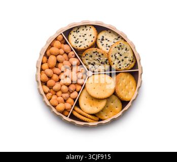 Diverses collations salées dans un bol rond isolé sur un fond blanc. Banque D'Images