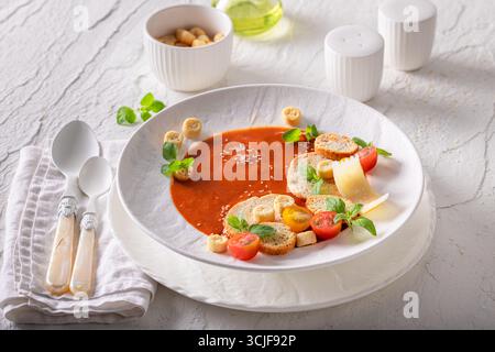 Soupe de tomates exclusive comme nourriture de haute qualité dans un restaurant sophistiqué. Soupe de tomates avec une décoration exquise. Banque D'Images