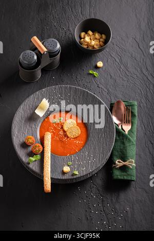 Soupe de tomates exquise comme nourriture de haute qualité dans un restaurant sophistiqué. Soupe de tomates avec une décoration exquise. Banque D'Images