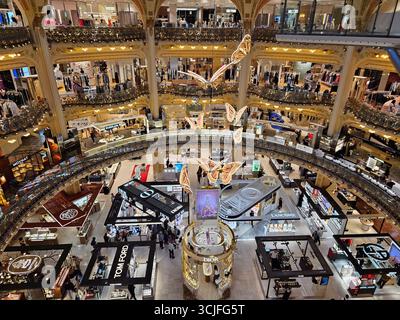 Paris, France. 14 mai 2025, intérieur des Galeries Lafayette aux décorations papillon illuminant les boutiques de luxe à Paris Banque D'Images