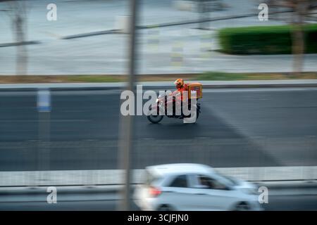 Doha, Qatar - 30 août 2025 : livreur Talabat livreur de nourriture sur la route Banque D'Images