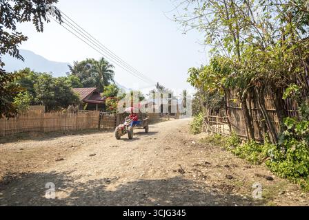 Vang Vieng, Laos - Feb 2016 : l'homme de la conduite du tracteur à travers le village près de Vang Vieng, Laos Banque D'Images