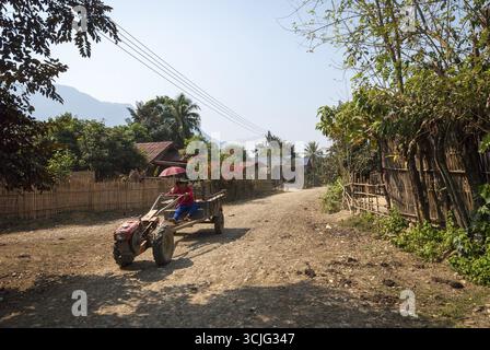 Vang Vieng, Laos - Feb 2016 : l'homme de la conduite du tracteur à travers le village près de Vang Vieng, Laos Banque D'Images