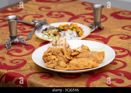 Boulettes poêlées disposées sur une assiette blanche. Boulettes russes frites (pelmeni). Pelmeni frit traditionnel, raviolis, boulettes fourrées de viande. Banque D'Images