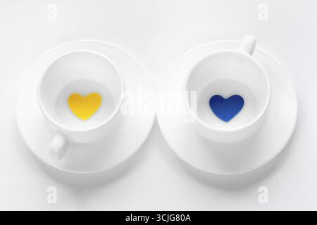 Tasse vide et soucoupe avec des coeurs sur blanc Banque D'Images