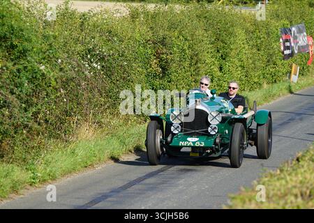 Voiture ancienne conduisant sur Country Road avec deux passionnés appréciant le voyage. Shere Hill Climb, East Clandon, Guildford Banque D'Images