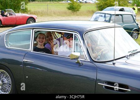 Famille profitant d'une balade en voiture classique à un salon de voitures anciennes. Shere Hill Climb, East Clandon, Guildford Banque D'Images