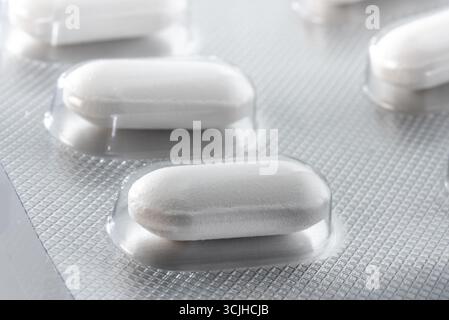 Comprimé enrobé d'ibuprofène gros plan dans l'emballage blister, pilule de médicament pour traiter l'inflammation, la douleur, et la fièvre. Banque D'Images