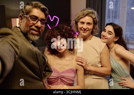 Groupe multiethnique d'adultes d'âge moyen et de jeunes adultes souriant et posant ensemble Banque D'Images