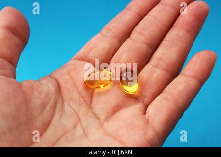 Main tenant plusieurs capsules molles de vitamine E. Banque D'Images