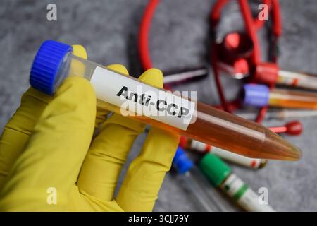 Médicament vaccinal anti-CCP dans les mains gantées jaunes. Concept médical Banque D'Images