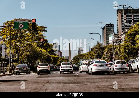 Buenos Aires, Argentine – 21 décembre 2022 : la circulation s'arrête sur l'Avenida 9 de Julio avec l'emblématique Obélisque visible au loin sous un ciel clair. Banque D'Images