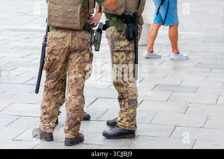 Une patrouille militaire se tient sur la place d'une ville italienne en pleine vitesse Banque D'Images