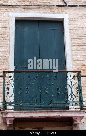 Volets verts et un balcon sur la brique fa ade de la maison Banque D'Images