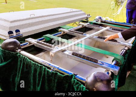 Des amis de la famille se rassemblent pour dire adieu final à la cérémonie d'enterrement au cimetière pendant la cérémonie funéraire Banque D'Images