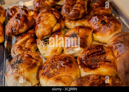 Un plateau de pâtisseries turques fraîchement cuites garni de graines de sésame et de pavot est exposé dans une boulangerie. Banque D'Images