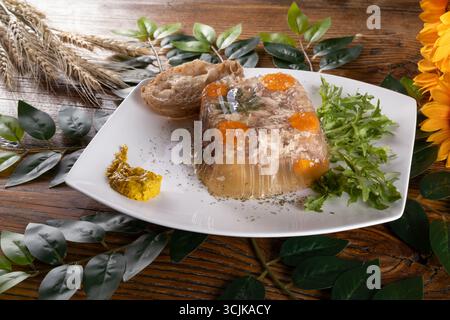 Une photo présentant Kholodets, un plat traditionnel ukrainien aspic, présenté avec de la viande et de la gelée, soulignant sa texture unique et sa richesse culturelle Banque D'Images