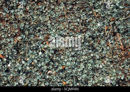 Texture en gros plan de particules de recyclage de verre broyé, montrant des fragments tranchants et des surfaces réfléchissantes colorées pour le thème du recyclage et de la durabilité Banque D'Images