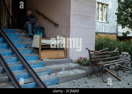 Un homme est assis en haut des escaliers travaillant sur son ordinateur portable dans un immeuble endommagé par la récente grève russe dans le quartier de Sviatoshynskyi à Kiev, en Ukraine, le 7 septembre 2025. La Russie a attaqué l'Ukraine avec des drones et des missiles de croisière dans la nuit du 7 septembre. À Kiev, une femme et un bébé sont morts et 20 personnes ont été blessées. (Photo Danylo Antoniuk/Ukrinform) Banque D'Images