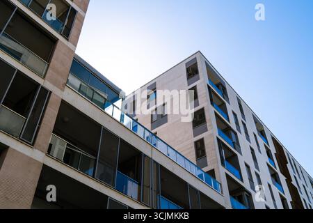 Complexe résidentiel moderne avec divers immeubles d'appartements, balcons et design urbain sous un ciel bleu vif. Banque D'Images