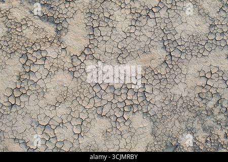 Une vue aérienne de la terre cuite par le soleil révèle une tapisserie de fissures, gravant un motif dur à travers le paysage desséché, Heniches'ka Hirka, oblast de Kherson, Ukraine. Banque D'Images