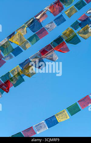 Drapeaux de prière tibétains (cheval à vent), volent au-dessus des niveaux inférieurs du Stupa Boudhanath à Katmandou, Népal. Banque D'Images