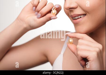 Vue rognée de la femme prenant des suppléments de beauté pour la peau éclatante Banque D'Images