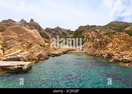 Étroite crique rocheuse avec des eaux turquoises claires et des falaises escarpées à Cala Candeo, île de Caprera, archipel de la Maddalena, Sardaigne, Italie. Banque D'Images