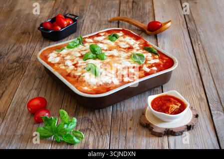 Gnocchi alla sorrentina cuit dans une poêle, avec basilic frais, tomates cerises et sauce tomate riche, incarnant la cuisine napolitaine traditionnelle Banque D'Images