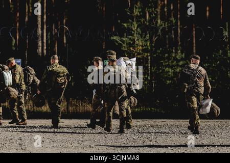 Des soldats marchent avec des sacs à dos, photographiés au Centre de soutien des convois temporairement érigé dans la zone d’entraînement militaire d’Oberlausitz près de Weisskeissel, le 6 septembre 2025. En septembre, une zone de repos et de rassemblement à commande civile pour un déploiement militaire sera mise en place dans la zone d'entraînement militaire d'Oberlausitz. Les forces armées traversent l'Allemagne en passant par la Pologne pour se rendre en Lituanie dans le cadre du sous-exercice Grand Eagle, qui fait partie du groupe d'exercices Quadriga 2025. En cours de route, ils seront approvisionnés au Centre de soutien aux convois (CSC), exploité exclusivement par Rheinmetall. Banque D'Images