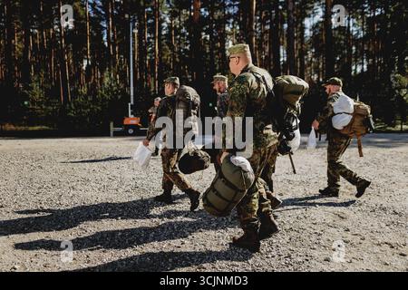Des soldats marchent avec des sacs à dos, photographiés au Centre de soutien des convois temporairement érigé dans la zone d’entraînement militaire d’Oberlausitz près de Weisskeissel, le 6 septembre 2025. En septembre, une zone de repos et de rassemblement à commande civile pour un déploiement militaire sera mise en place dans la zone d'entraînement militaire d'Oberlausitz. Les forces armées traversent l'Allemagne en passant par la Pologne pour se rendre en Lituanie dans le cadre du sous-exercice Grand Eagle, qui fait partie du groupe d'exercices Quadriga 2025. En cours de route, ils seront approvisionnés au Centre de soutien aux convois (CSC), exploité exclusivement par Rheinmetall. Banque D'Images