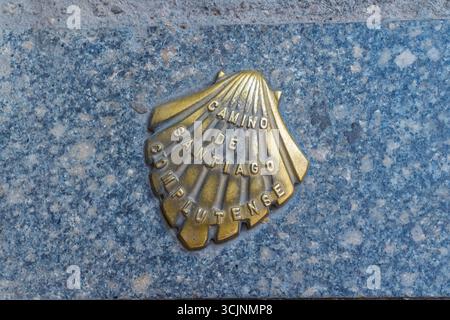 Alcalá de Henares, Espagne. 20 août 2025. Un petit marqueur métallique en forme de coquille Saint-Jacques pour la route du Camino de Santiago Complutense Banque D'Images