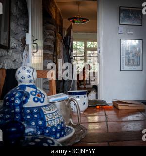 Chien boxeur assis sur le banc dans le couloir, vu de la cuisine Banque D'Images