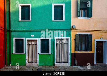 Maisons colorées de l'île de Burano brillantes dans la lumière chaude du coucher du soleil d'automne, près de Venise, Italie. Banque D'Images