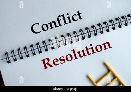Conflict Resolution, bloc-notes avec les mots en gras Conflict Resolution écrits sur sa feuille blanche lignée sur un bureau Banque D'Images