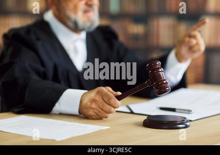 Le juge frappe le marteau pendant l'audience du tribunal rendant une décision judiciaire dans la salle d'audience Banque D'Images
