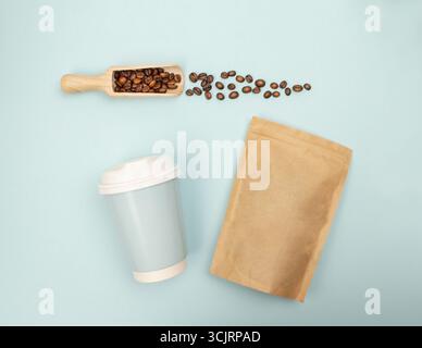 Pose à plat avec des grains de café tombant dans le gobelet en papier, capturés depuis le plafond pour une utilisation dans les visuels de marque et de produit. Vue de dessus. Pose à plat. Banque D'Images