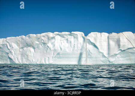 Cascade du glacier de Bråsvellbreen Vibebukta Nordaustlandet Svalbard // NORDEAUSTLANDET, SVALBARD — Une cascade de glace coule du bord du glacier de Bråsvellbreen lorsque la glace fond et coule vers la mer. Bråsvellbreen est l'un des plus grands glaciers de l'île de Nordaustlandet, qui fait partie de l'archipel du Svalbard situé dans l'océan Arctique. Le front de glace du glacier est une caractéristique dynamique, constamment façonnée par les processus de fonte et de vêlage. Banque D'Images