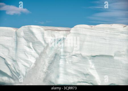 Cascade du glacier de Bråsvellbreen Vibebukta Nordaustlandet Svalbard // NORDEAUSTLANDET, Svalbard — Cascades d'eau de fonte à partir du bord du glacier de Bråsvellbreen, formant une cascade temporaire en direction de la mer. Bråsvellbreen est l'un des plus grands glaciers du Svalbard, situé dans la partie nord-est de l'île Nordaustlandet. Ce phénomène d'eau de fonte glaciaire est un spectacle courant pendant les périodes plus chaudes, mettant en évidence la nature dynamique des formations de glace polaire. La vaste calotte glaciaire du glacier contribue grandement au paysage et à l'écosystème de la région. Banque D'Images