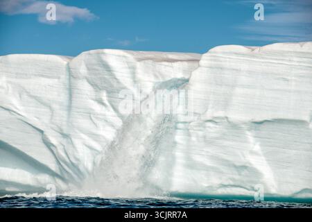 Cascade du glacier de Bråsvellbreen Vibebukta Nordaustlandet Svalbard // NORDEAUSTLANDET, Svalbard — Une chute d'eau coule du bord du glacier de Bråsvellbreen lorsque la glace fondante coule vers la mer. Bråsvellbreen est l'un des plus grands glaciers de la calotte glaciaire d'Austfonna, situé sur la partie nord-est de l'île de Nordaustlandet dans l'archipel du Svalbard. Le terminus du glacier fait face à la mer de Barents, et l'eau de fonte forme souvent des caractéristiques spectaculaires comme cette cascade. Banque D'Images