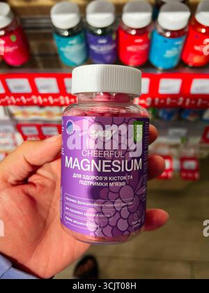 Kiev, Ukraine - 10 août 2025 : bouteille en plastique contenant des suppléments de magnésium, exposée dans un environnement de magasin de nutrition. Banque D'Images
