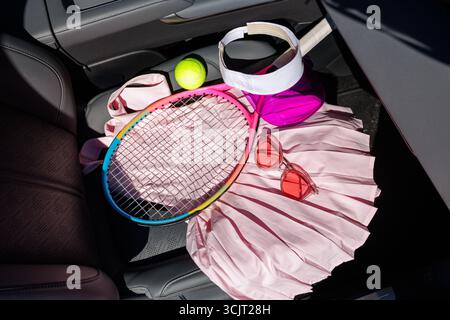 Pose à plat élégante d'équipement de tennis et d'accessoires de mode, y compris visière jupe de balle de raquette et lunettes de soleil sur le siège d'auto Banque D'Images