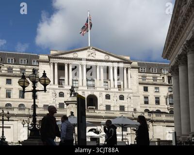 Des travailleurs professionnels vus sur la place devant le siège de la Banque d'Angleterre avec Union Jack Flying sur le toit du bâtiment historique. Banque D'Images