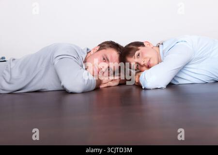 couple couché sur le plancher en bois Banque D'Images