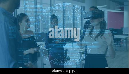 Femme gestuelle portant un casque VR montrant la superposition dans le bureau avec des pairs regardant, copiez l'espace Banque D'Images