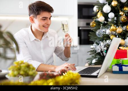homme communique joyeusement par appel vidéo le soir du nouvel an Banque D'Images
